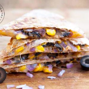 Stuffed Mexican Quesadillas stacked on a cutting board.