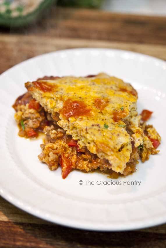 Clean Eating Sloppy Joe Casserole cut and served on a white plate. The bread-like topping sits on top of the ground meat.