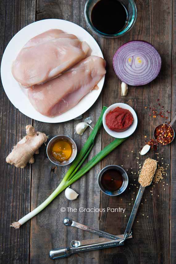 Clean Eating Slow Cooker Honey Sesame Chicken recipe ingredients laid out individually on a wooden table top.
