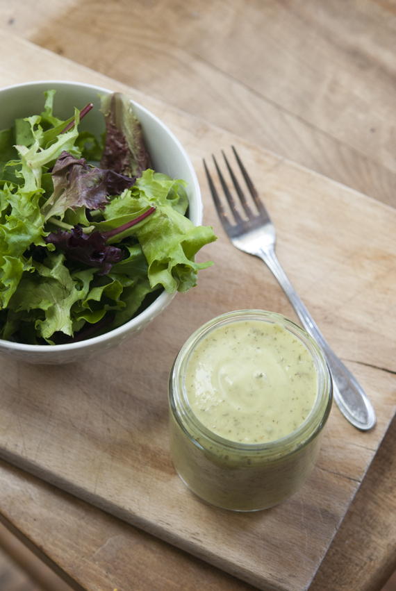 mason jar of avocado lime ranch dressing next to garden salad