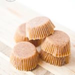 Five of these Clean Eating Peanut Butter Fat Bombs sit on a cutting board, ready to eat.