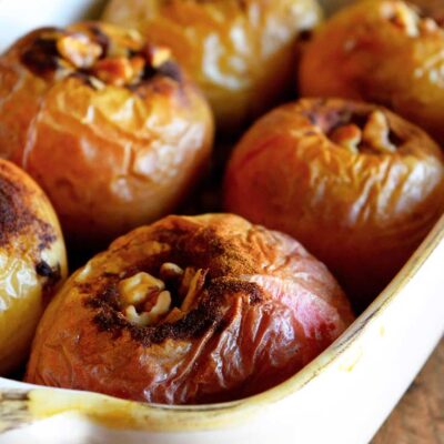 A pan of baked apples sits warm out of the oven, ready to serve.