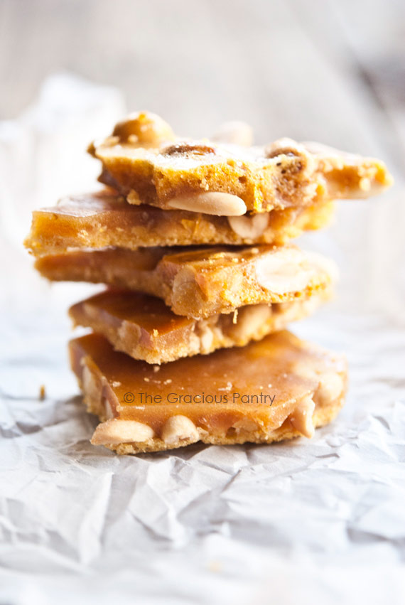 A stack of homemade peanut brittle on a white background, made from a peanut brittle recipe without corn syrup