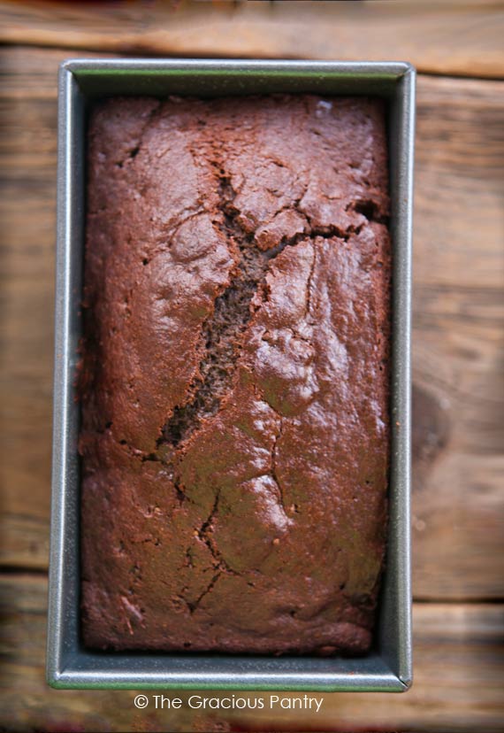 A peppermint Chocolate bread Loaf sits in the bread pan it was baked in.