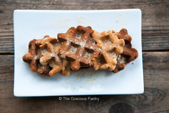 An overhead view of three waffle iron cookies on a white, rectangular platter.