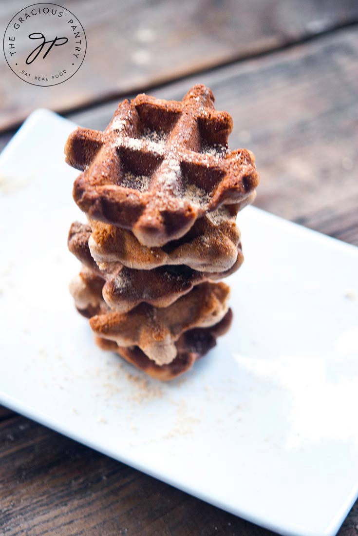 A stack of these Waffle Iron Cookies sits on a white platter for serving at your holiday table.