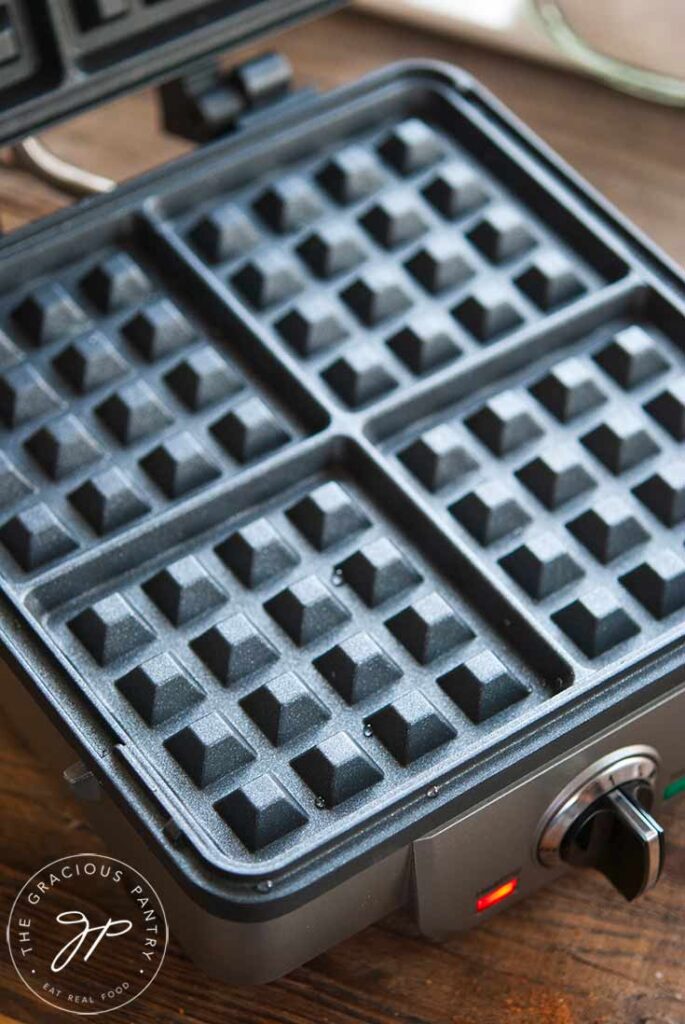 An open waffle iron sitting on a countertop.