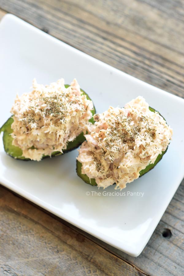 An overhead view of two avocado halves stuffed with tuna salad.