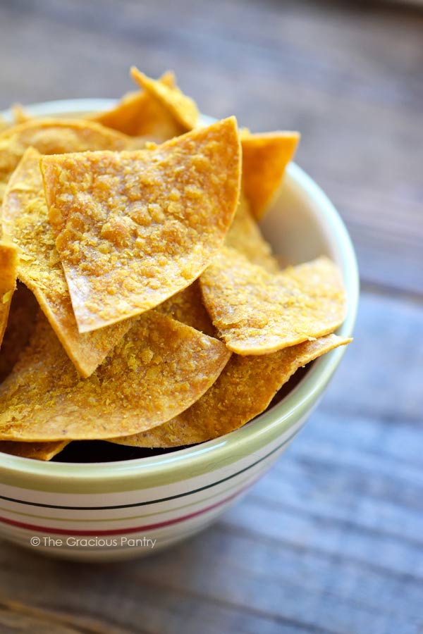 An overhead sideview of a bowl filled with homemade Doritos.