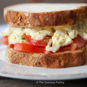 An Egg Salad Sandwich sitting on a white plate.