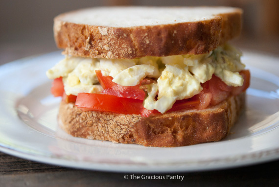 An Egg Salad Sandwich sitting on a white plate.