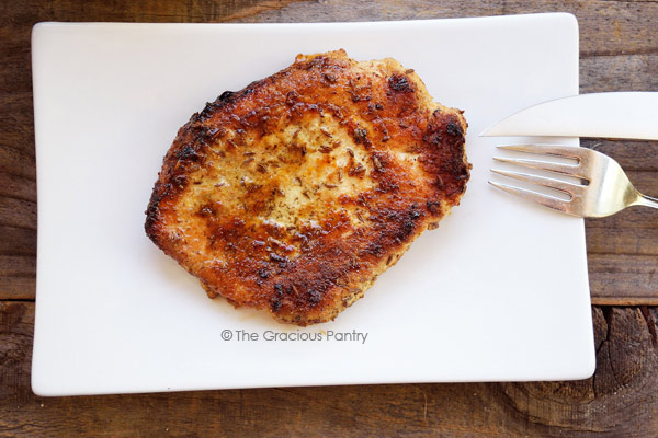 Clean Eating Caraway Seed Pork Chops make a wonderful, clean eating Valentine's Day main course for dinner. Pork chops served on a white plate.