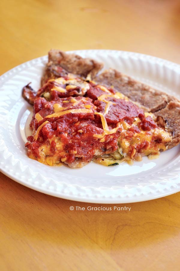 A single slice of this Clean Eating Pizza Pie on a white plat, shown up close.