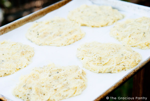 Several Clean Eating Single Serving Spaghetti Squash Pizza Crusts have just been mixed and formed and sit on a baking tray, ready to be baked.