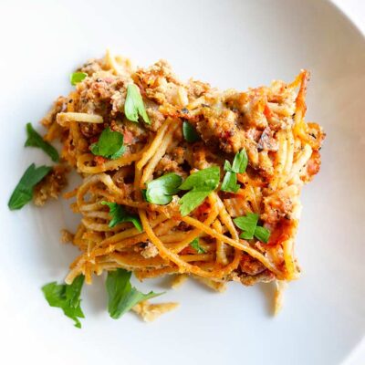 A slice of spaghetti pie in a white bowl.