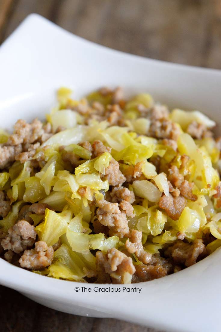 Clean Eating Cabbage Hash shown up close in a white bowl. You can see the ground turkey and ribbons of green cabbage mixed together