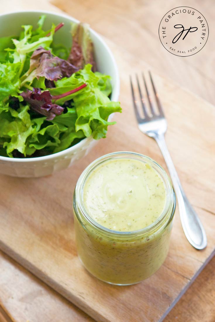 mason jar of avocado lime ranch dressing next to garden salad