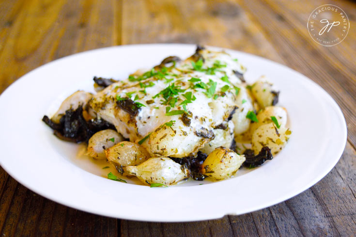 Sheet Pan Mushroom And Onion Cod on a white plate.