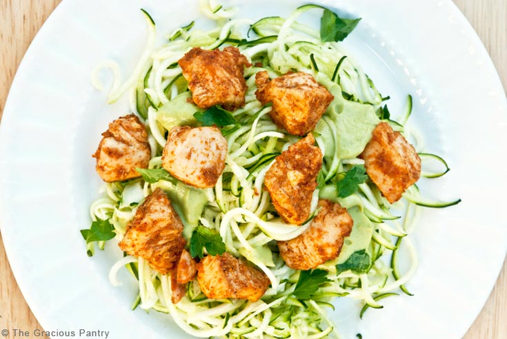 An overhead view of a white plate filled with zoodles and topped with taco chicken.