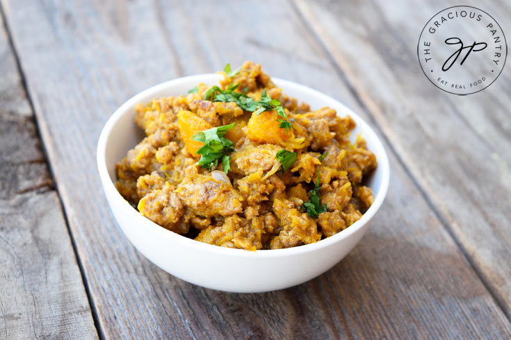 A single white bowl filled with Ground Turkey Pumpkin Skillet sitting on a wood surface.