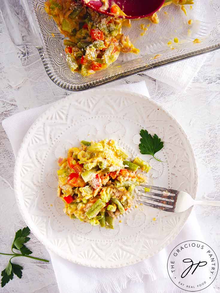 An overhead view looking down onto a table set with dishes and a serving of this No Noodle Tuna Casserole on one of the plates.
