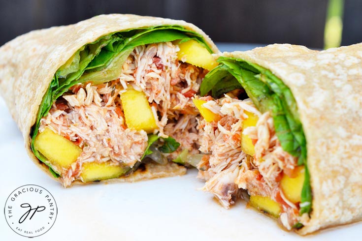 This Clean Eating Mango Chicken Wrap cut in half and ready to sink your teeth into