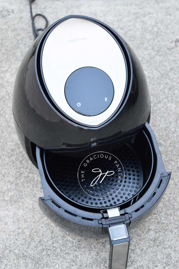Modern Home Air Fryer with the food basket or drawer open.