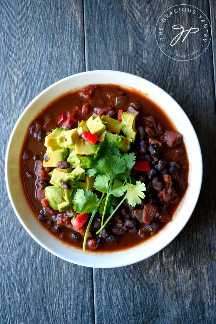 An overhead view of this Clean Eating Mexican Black Bean Chili shows the details of this chili. The beans, bits of tomatoes and pepper, as well as the toppings of avocado and fresh cilantro, all come together to make one beautiful bowl of black bean chili!