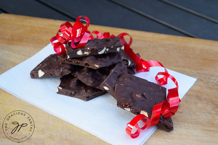 A side view of a pile of Chocolate Bark with some red gift ribbon laying over part of it.