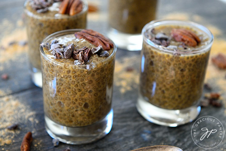 A horizontal shot showing four shooter glasses filled with this Clean Eating Maca Chia Seed Pudding.