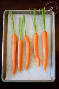 A tray of carrots sits ready for roasting in this clean eating maple glazed carrots recipe.