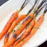 A side view of these clean eating maple glazed carrots shown in an oval serving dish.
