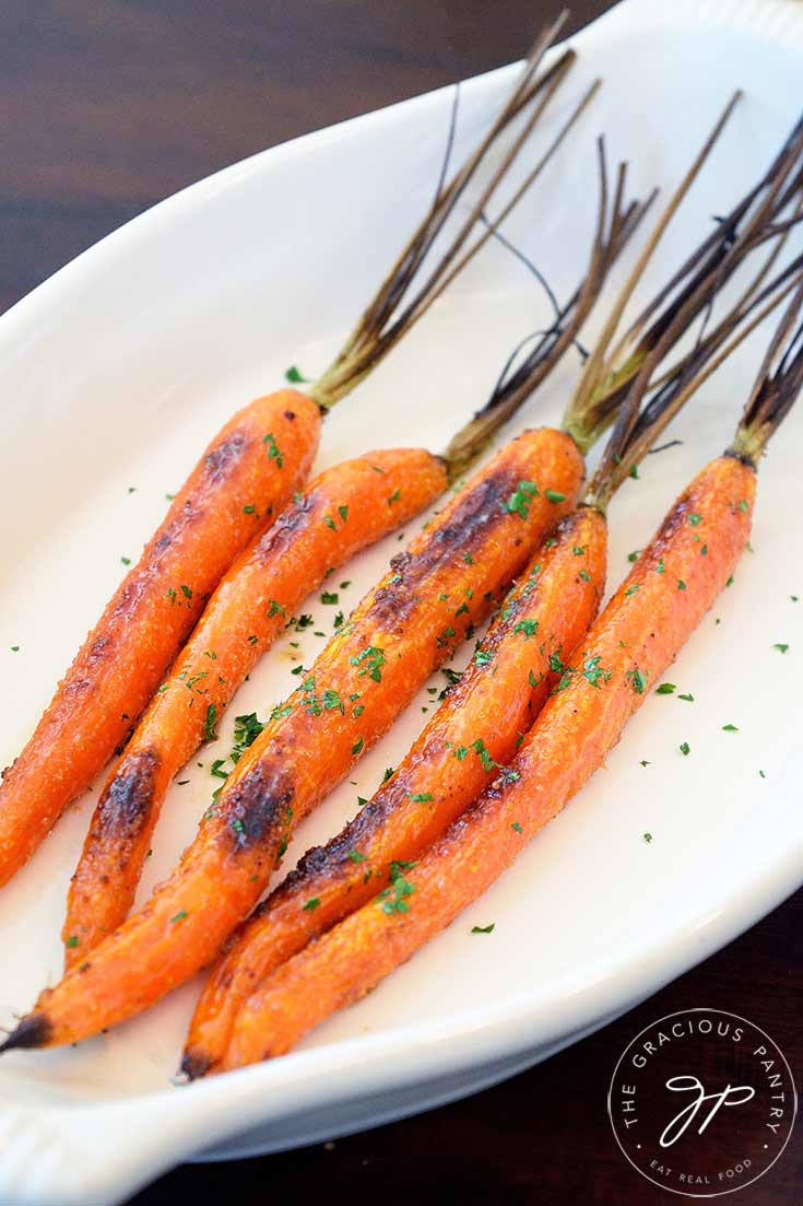 A side view of these clean eating maple glazed carrots shown in an oval serving dish.