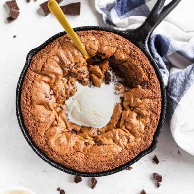 And overhead shot of this Clean Eating Skillet Chocolate Chip Cookie with a scoop of vanilla ice cream melting in the middle of the warm cookie.