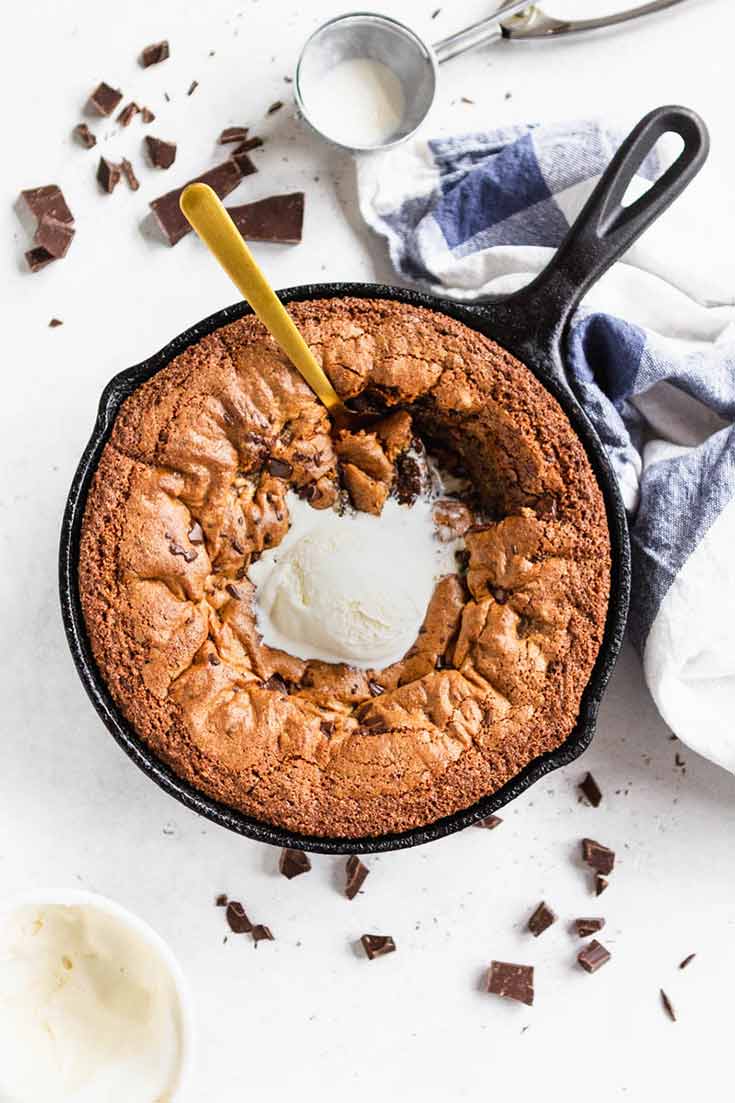 And overhead shot of this Clean Eating Skillet Chocolate Chip Cookie with a scoop of vanilla ice cream melting in the middle of the warm cookie.