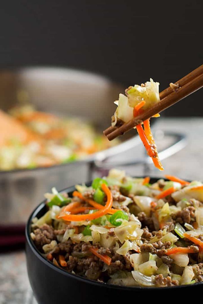 grabbing egg roll mixture from bowl with chopsticks