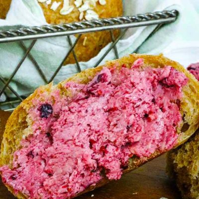 A single slice of whole grain bread sits next to it's loaf and is topped with this Triple Berry Honey Butter
