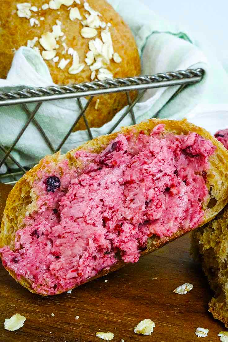 A single slice of whole grain bread sits next to it's loaf and is topped with this Triple Berry Honey Butter