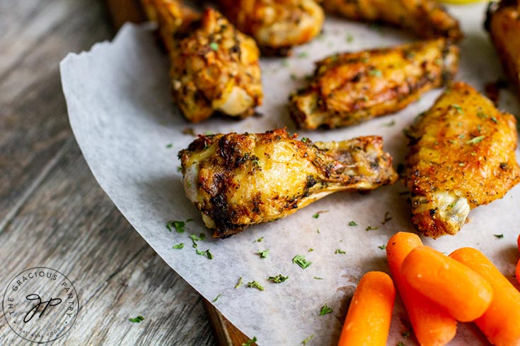 The finished Air Fryer Chicken Wings Recipe sits ready to eat on some parchment paper.