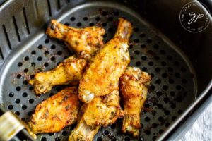 Step 6 shows the cooked wings sitting in the air basket after just finishing cooking.