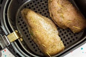 To cook this Air Fryer Chicken Breasts Recipe, place the prepared chicken breast into the air fryer basket.