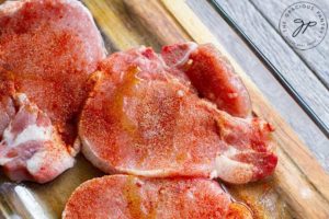 Pork chops seasoned with spices, ready for the air fryer.