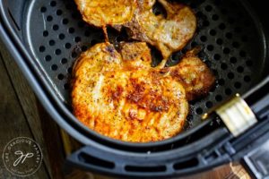 Just cooked pork chops still sitting in the air fryer basket.