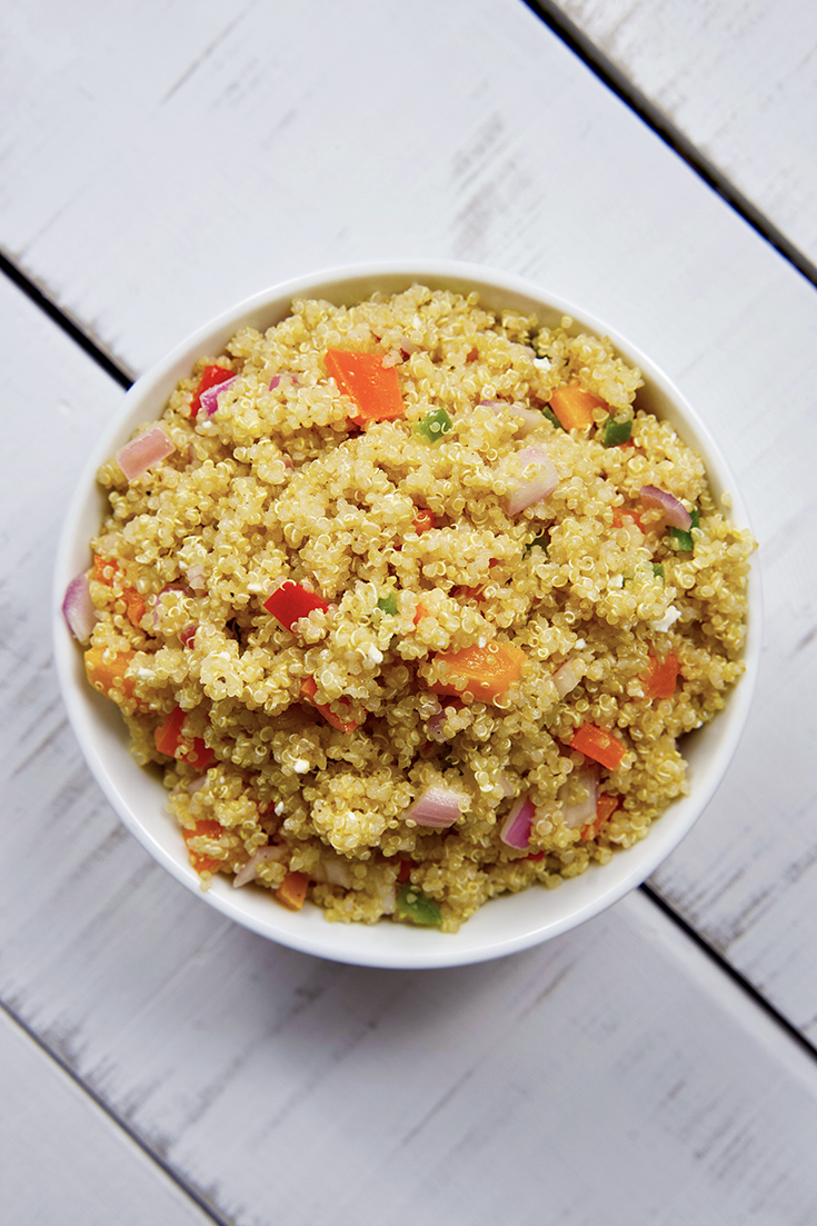 An overhead shot looking down into a white bowl filled with this Clean Eating Mediterranean Quinoa Salad.