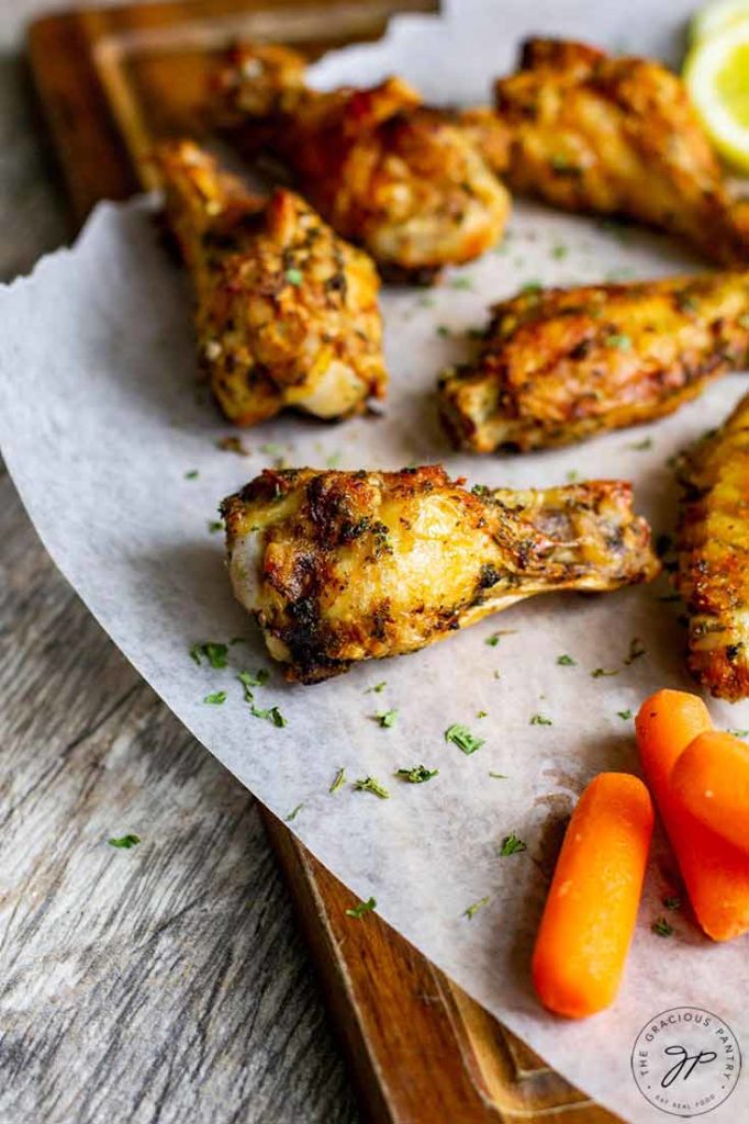 A batch of Air Fryer Chicken Wings sit ready to eat on parchment paper.