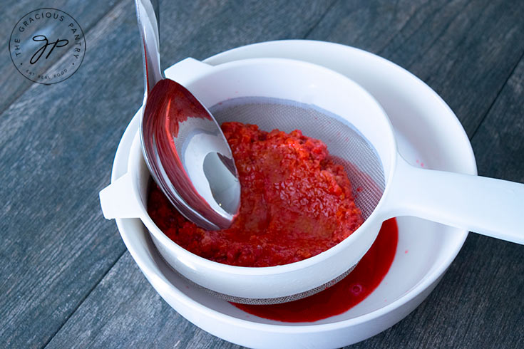 Step three shows the raspberries being mashed through the sieve to extract the juice and pulp without the seeds.