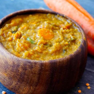 A delicious bowl of this Sweet Potato Curry Recipe shows a wooden bowl filled with curry, ready to eat.