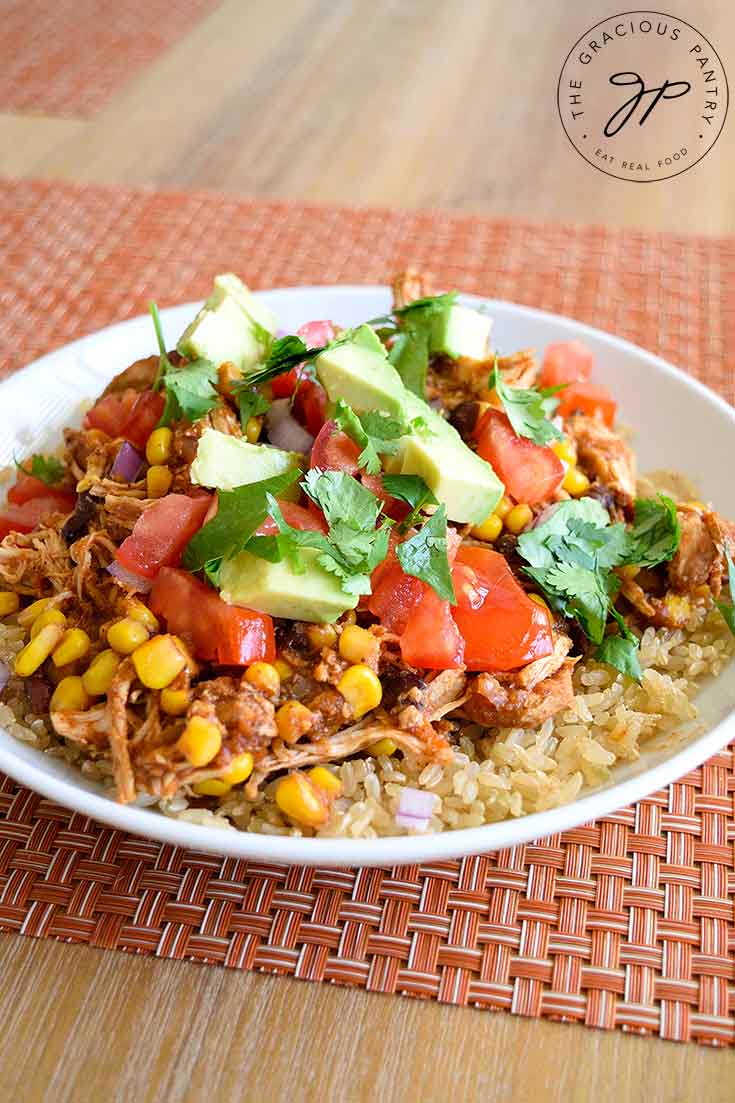 Instant Pot Mexican Chicken sits in a white bowl, garnished with toppings and ready to eat.