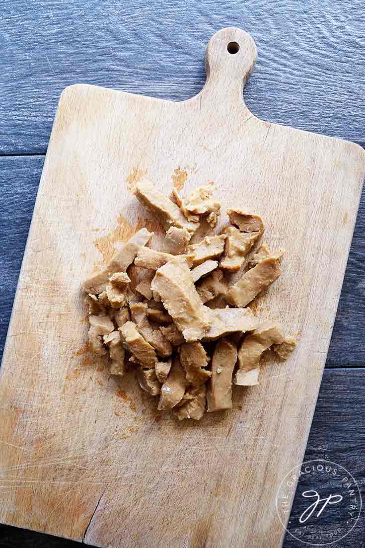 This image, shows pieces of Seitan on a wooden cutting board.