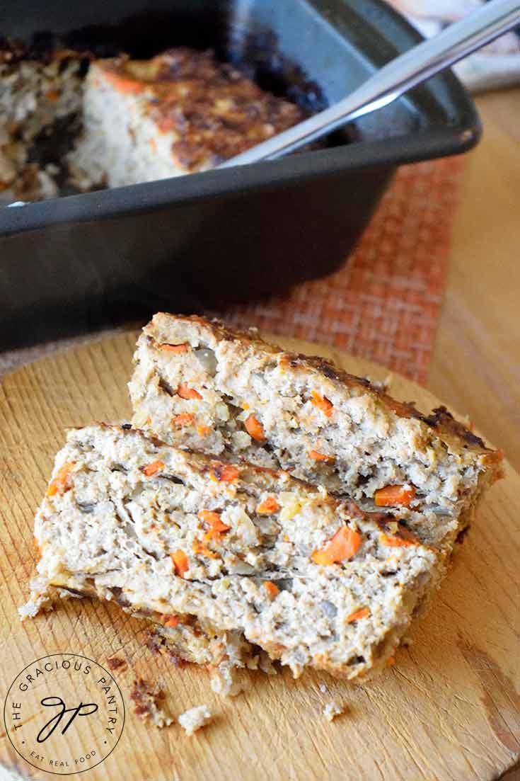 Slices of ground turkey meatloaf sit on a cutting board, ready to serve.